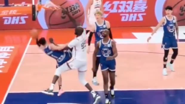 Tacko Fall dunks on a defender and sends him crashing to the floor